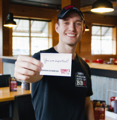Sonny's employee shows off card given to him by co-workers
