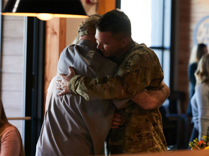 Sonny's Team Member and active-duty military officer embrace