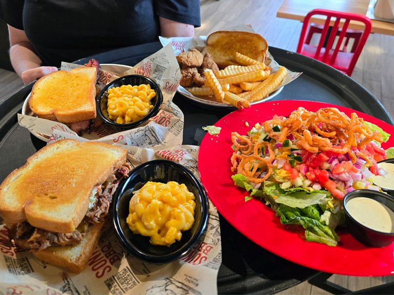 Sandwiches, Salads and more BBQ from Sonny's BBQ Gonzales sits on a server's plate.